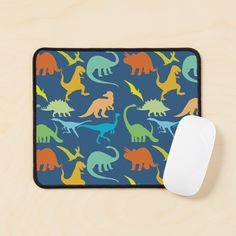 a mouse pad with colorful dinosaurs on it next to a computer mouse and a keyboard