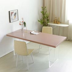 a table with two chairs next to it and a vase on the table in front of it