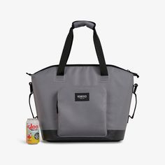 a gray and black tote bag next to a bottle of boobee juice on a white background