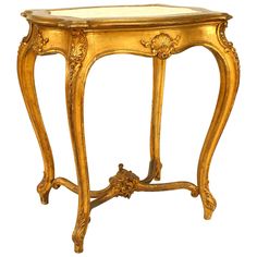 an ornately decorated table with gold paint and wood trimmings on the top