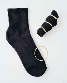 a pair of black socks with gold rings on them next to a small hoop earrings