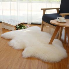 a white sheepskin rug sitting on top of a wooden floor next to a chair