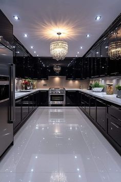 a large kitchen with black cabinets and white flooring, chandelier above the stove