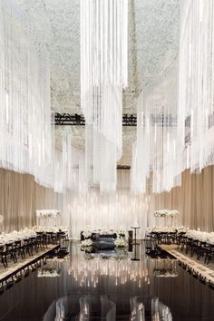 the interior of a restaurant with chandeliers hanging from the ceiling and tables set for dinner