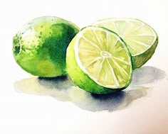 two limes with one cut in half sitting next to each other