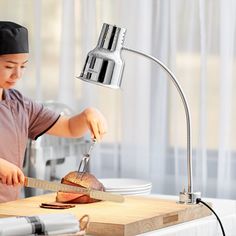 a woman is cutting some bread on a board