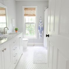 a white bathroom with hexagonal tile flooring