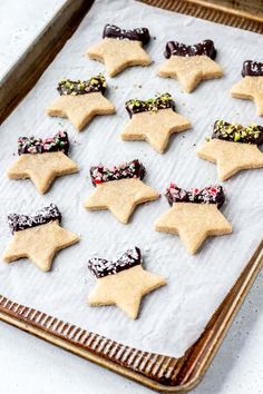 cookies decorated with chocolate and sprinkles in the shape of stars on a baking sheet