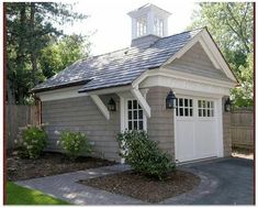 a small gray and white house with a clock tower on top of it's roof