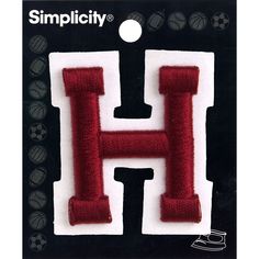 the letter h is made out of felt and has a soccer ball on it's back