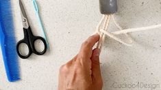 a person tying a rope with scissors and combs on the table next to them