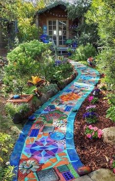 a garden path is painted with colorful tiles