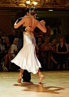 a man and woman are dancing on the dance floor