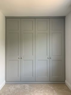 an empty room with gray cabinets and carpeted flooring in front of white walls