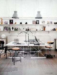 an office with two desks and shelves on the wall above them is shown in this photograph