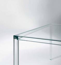 a clear glass table sitting on top of a white floor