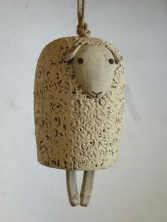 a ceramic sheep ornament hanging from a rope