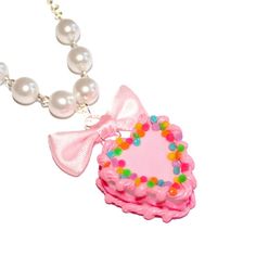 This adorable miniature birthday cake necklace is a special way to celebrate your birthday or make everyday your birthday! It was inspired by all those fabulous kitschy and girly pink birthday cakes we had growing up.This cake is adorned with classic birthday cake details like pink piped frosting, frilly bright pink icing along the middle, and topped with bright rainbow confetti sprinkles. The cake hangs below a lovely pink bow from a high quality glass pearl beaded chain and silver plated chain Pink Heart-shaped Charm Necklace For Party, Pink Heart Charm Necklace For Party, Pink Kawaii Jewelry For Valentine's Day, Kawaii Pink Jewelry For Valentine's Day, Cute Necklaces For Mother's Day Party, Pink Necklace For Birthday And Mother's Day, Pink Necklace For Birthday Gift On Mother's Day, Pink Heart-shaped Jewelry For Birthday Gift, Cute Valentine's Day Party Necklaces