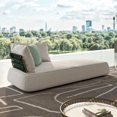 a white couch sitting on top of a rug in a living room next to a window