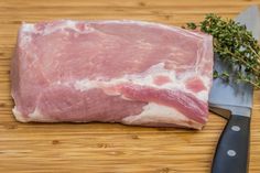 a piece of meat sitting on top of a cutting board next to a knife