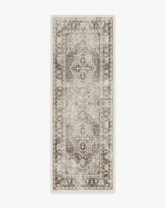 a rug with an ornate design on the bottom, and a white background behind it