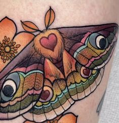 a close up of a tattoo with a butterfly on it's thigh and flowers in the background