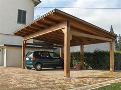 a car is parked under a wooden carport