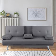 a grey couch sitting on top of a hard wood floor