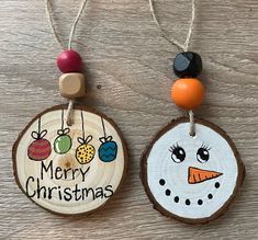 two christmas ornaments are hanging on wood slices