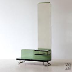 a tall green cabinet sitting on top of a white floor