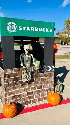 a starbucks skeleton sitting in the driver's seat of a car decorated for halloween