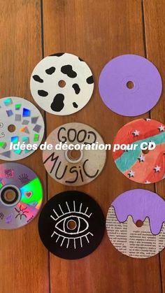 several different cd discs on a wooden floor with the words good music painted on them