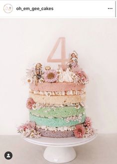 a multi layer cake sitting on top of a white plate next to a number four sign