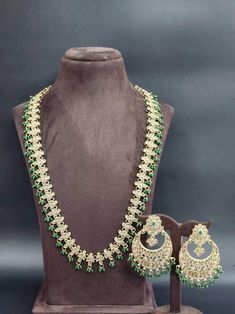 Indulge in the rich elegance of our Green Indian Bollywood Jewelry Set, a timeless embodiment of grace and allure. This captivating ensemble, comprising an exquisite choker necklace, coordinating earrings, and a delicate tikka, seamlessly weaves traditional opulence with contemporary sophistication.  Crafted with meticulous attention to detail, each piece showcases intricate craftsmanship and a fusion of cultural heritage with modern aesthetics. The necklace drapes gracefully along your neckline Elegant Gold Plated Bridal Necklace For Party, Elegant Gold-plated Bridal Necklace For Party, Elegant Bridal Necklace With Intricate Design For Party, Elegant Bridal Necklace With Intricate Design, Classic Necklace With Elegant Design For Celebrations, Wedding Kundan Necklace With Elegant Design, Elegant Necklaces With Intricate Design For Party, Classic Elegant Necklace For Celebration, Elegant Bridal Sets With Intricate Design For Party