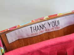 a close up of a purse with a thank you sign on it