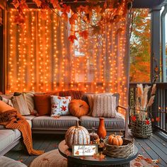 an outdoor living room with fall decorations and lights