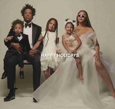 a group of people sitting next to each other in front of a white background with the words happy holidays written on it