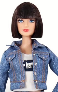 a barbie doll wearing a jean jacket and white shirt with her hands on her hips