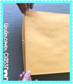 a hand holding a piece of yellow paper over the edge of a sheet of paper