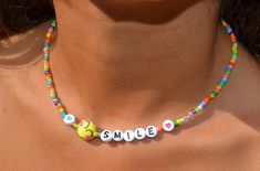 "This dainty necklace is a fun combination of varied, colorful seed beads combined with darling little, emoji smiling faces and the letters spelling smile with hearts.  It is super cute and darling. Lightweight and perfect for a little girl's gift! Clasp is a sterling magnetic clasp (for convenient wear and removal) and findings are all sterling silver. Necklace measures approximately just over 14\" Browse more fun items from my shop here: https://www.etsy.com/shop/uniquebeadingbyme?ref=seller-p Fun Beaded Necklaces With Tiny Beads For Gifts, Fun Beaded Necklace With Tiny Beads For Gift, Cute Everyday Necklaces With Colorful Beads, Trendy Colorful Beaded Necklaces With Letter Beads, Trendy Colorful Beaded Necklace With Letter Beads, Cute Everyday Beaded Necklaces, Trendy Birthday Necklace With Letter Beads, Fun Adjustable Necklace With Letter Beads, Fun Adjustable Letter Beads Necklace