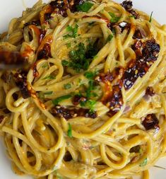 a white plate topped with pasta covered in sauce