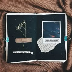 an open book with pictures and writing on it, sitting on a brown cloth covered surface