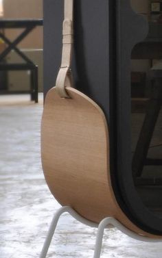 a wooden guitar hanging from the side of a black and white wall next to a window