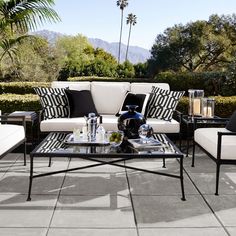 an outdoor living room with black and white furniture