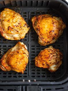 four pieces of chicken cooking in an air fryer