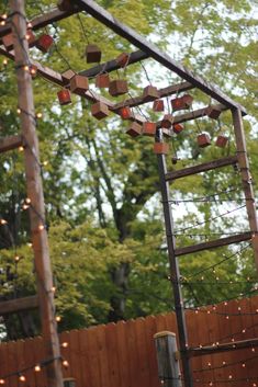 a wooden structure with lights hanging from it's sides and some trees in the background