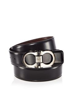 Salvatore Ferragamo's versatile reversible leather belt elevates any outfit with iconic Gancini buckle appeal. Featuring soft black and hickory leathers that flip to match your look, this prestigious belt holds strong with an adjustable gunmetal buckle marked by the legendary designer's signature. Crafted in Italy with the quality discerning fashionistas love Ferragamo for, personalize its length easily while enjoying years of refinement with every wear. #makeastatement #SalFerragamo #effortless Designer Formal Belts With Removable Belt, Designer Formal Belt With Removable Buckle, Designer Formal Belt With Removable Feature, Elegant Black Belt Buckles With Metal Logo, Luxury Black Belt Buckles With Logo Plaque, Designer Leather Belt Buckles With Palladium Hardware, Black Timeless Formal Belt Buckles, Timeless Black Formal Belt Buckles, Designer Black Belt Buckles With Palladium Hardware