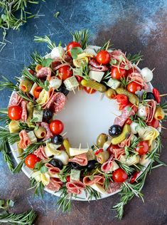 a platter filled with meats, olives and other vegetables on top of a table