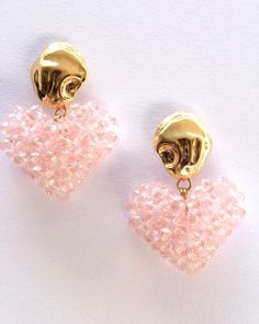 "Beaded heart earrings in pink. These beaded earrings are individually hand-beaded acrylic crystals finished with stone shapped gold plated brass earrings. Measures : 4.5 cm / 1.8\" Drop Materials : Acrylic beads, Gold plated brass post with sterling silver stud." Gold Crystal Heart Shaped Earrings, Valentine's Day Gold Crystal Earrings, Pink Heart Crystal Earrings For Valentine's Day, Gold Crystal Heart Earrings, Pink Heart-shaped Crystal Earrings For Valentine's Day, Gold Heart Shaped Crystal Earrings, Gold Heart-shaped Crystal Earrings, Gold Heart-shaped Jewelry With Faceted Beads, Pink Beaded Heart Earrings For Party