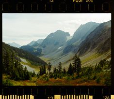 a scenic view of mountains and trees in the distance with a measuring tape around them